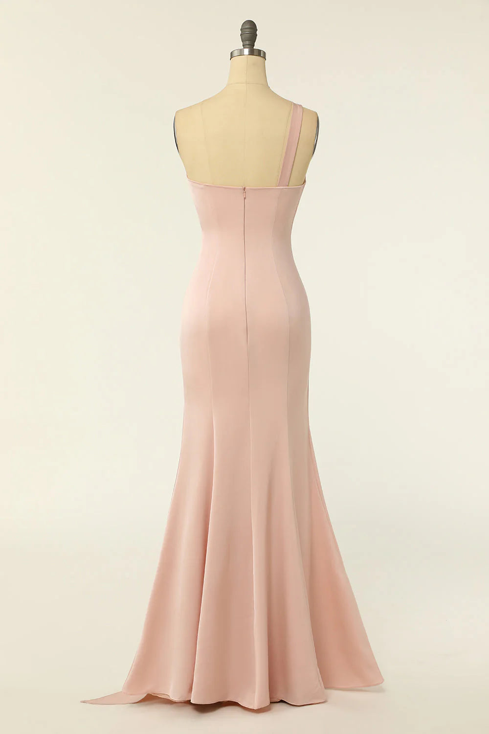 Side profile of a woman in a blush mermaid one-shoulder long dress.