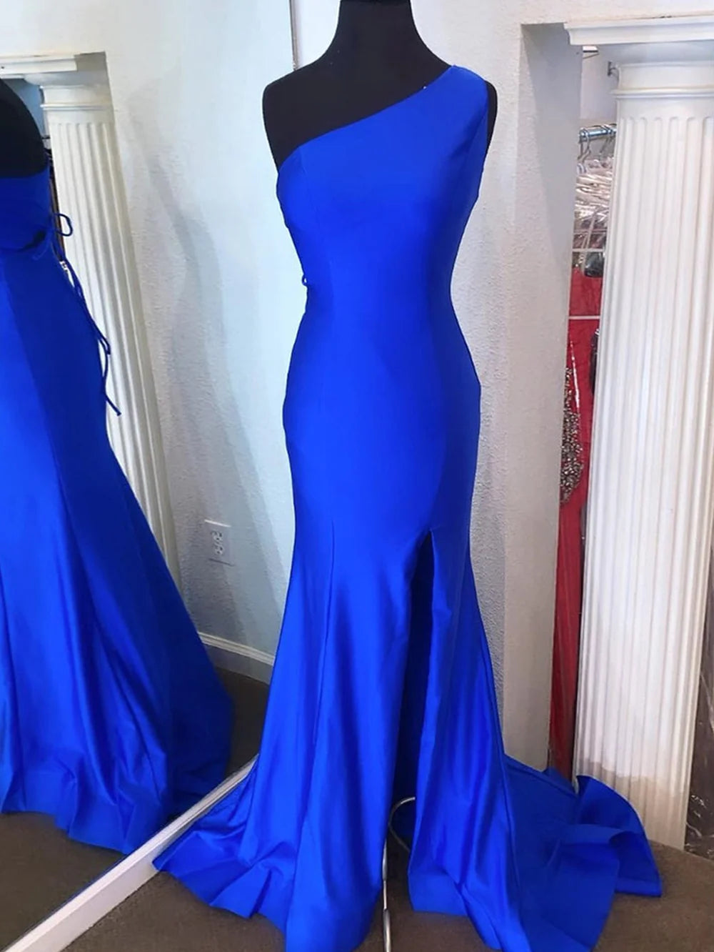 Woman posing in a shimmering mermaid one-shoulder long prom dress.