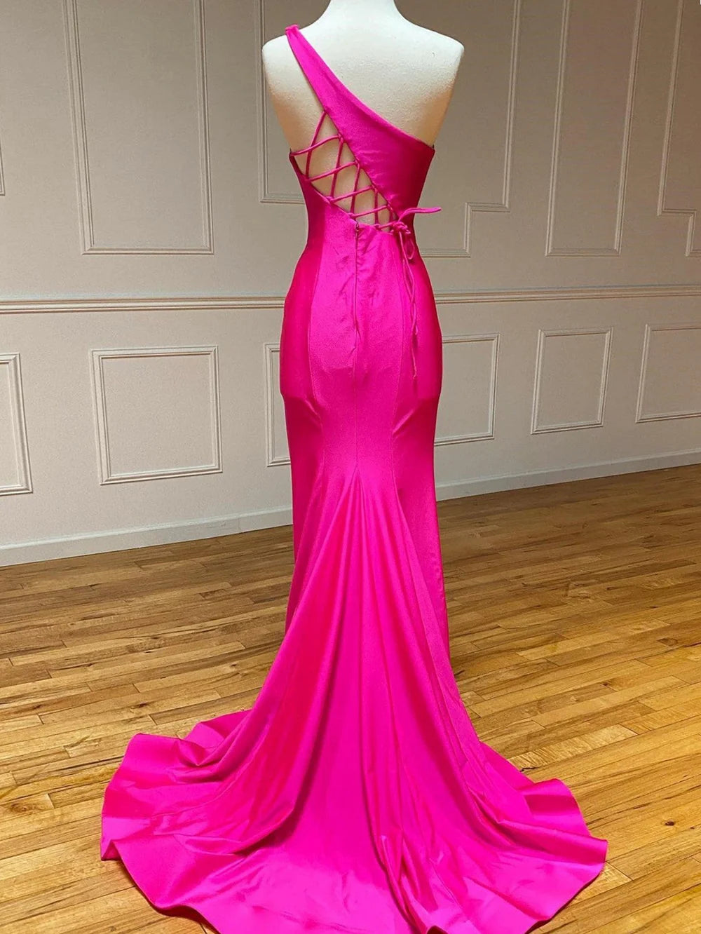 Woman gracefully walking in a mermaid one-shoulder long prom dress.