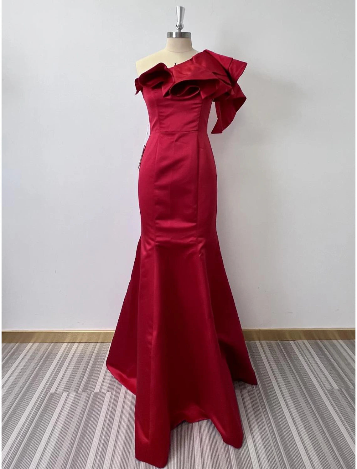 Woman in an elegant one-shoulder ruffled mermaid evening gown.