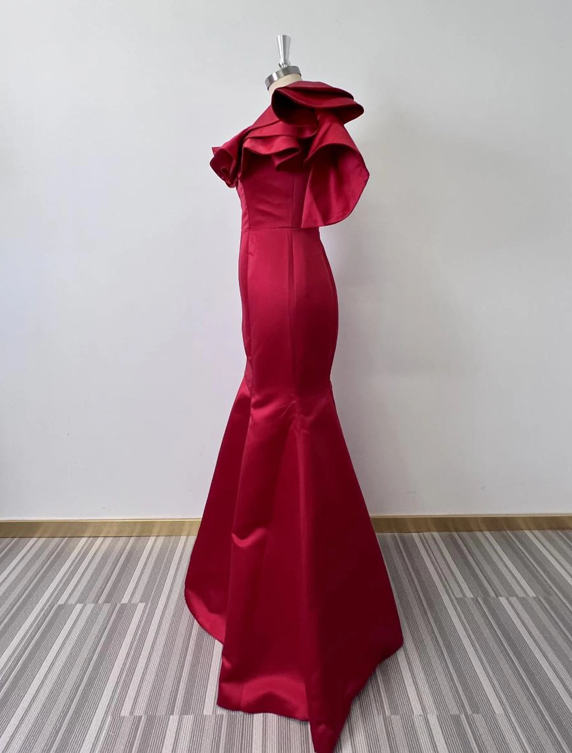 Back view of a one-shoulder taffeta mermaid dress with ruffles.