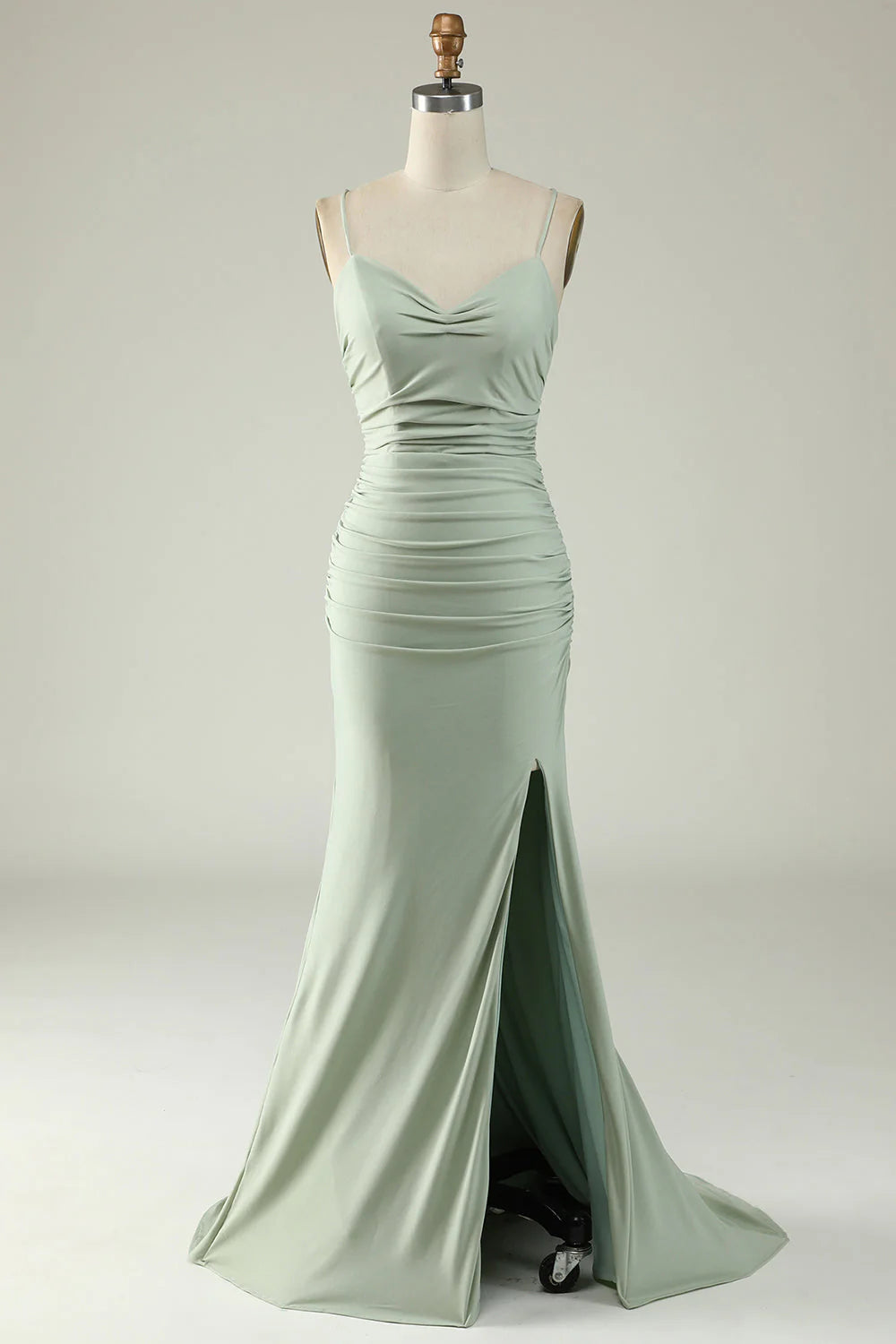 Model wearing a light green mermaid prom dress with a high slit.