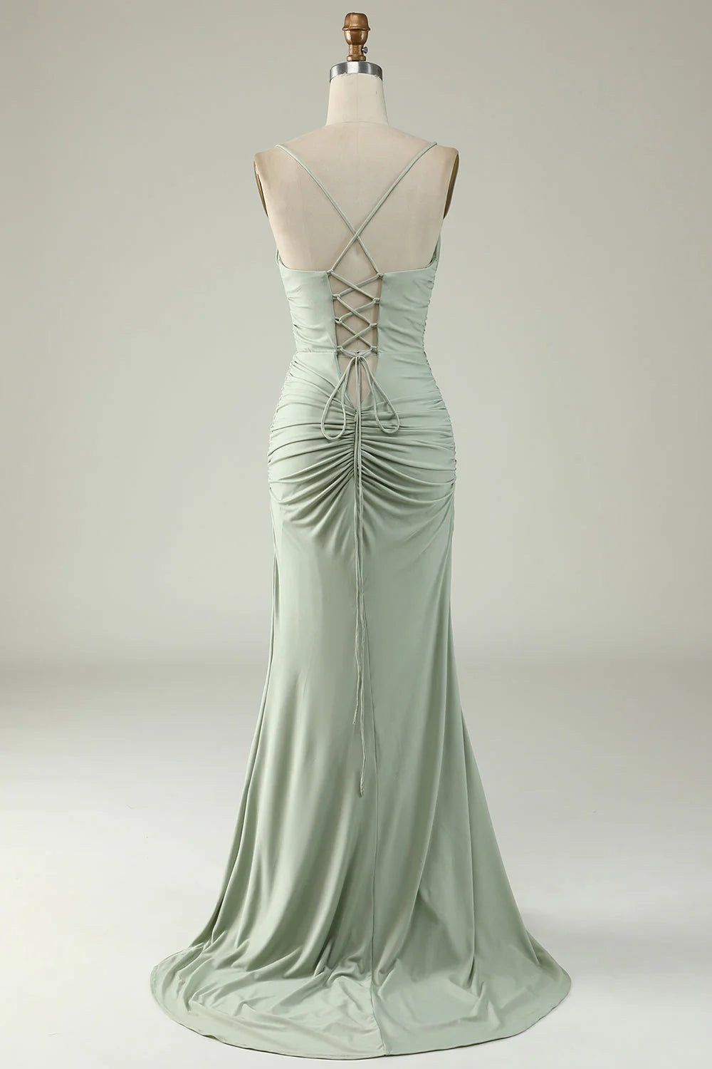 Side view of a model in a light green mermaid formal gown.