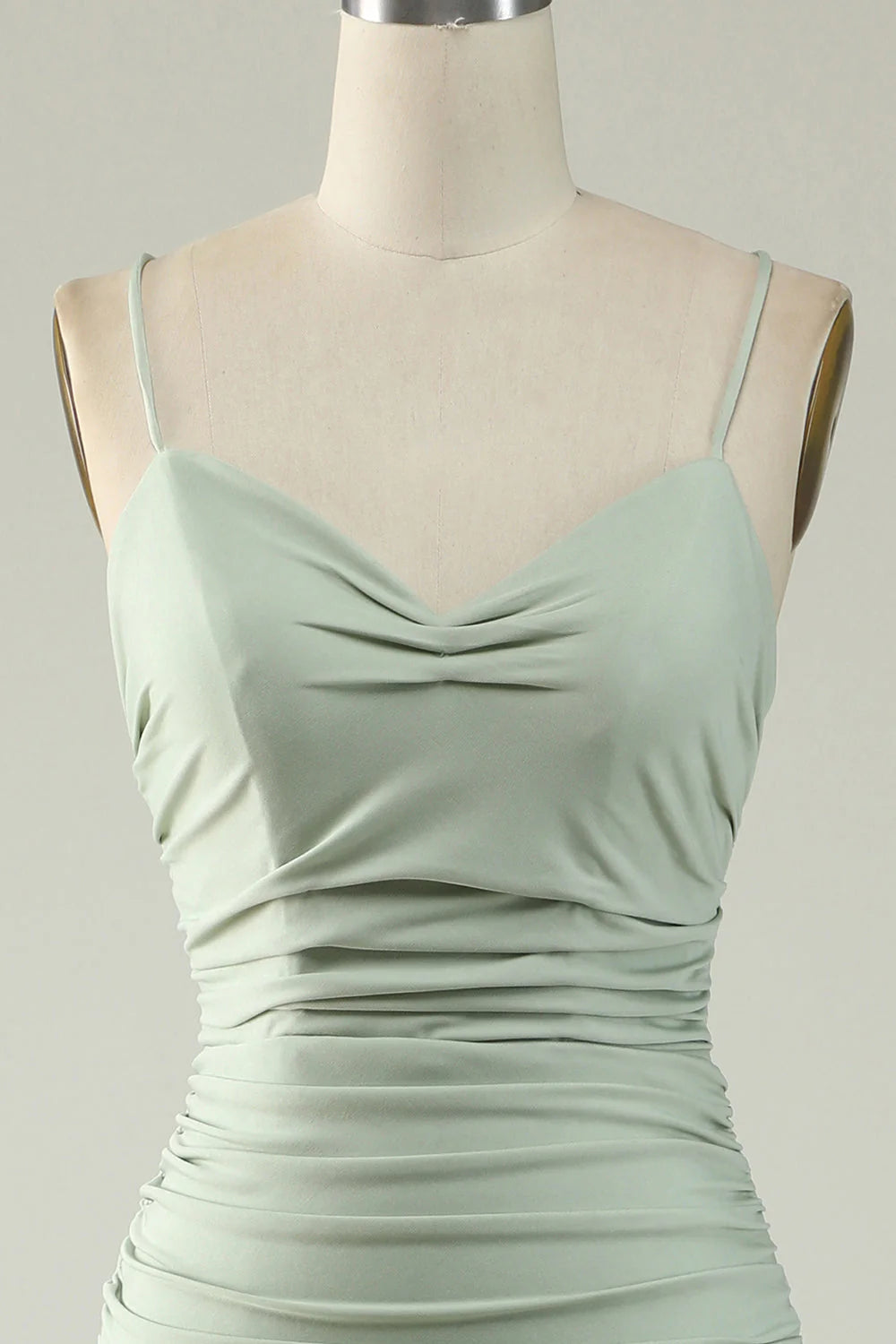 Close-up of the light green mermaid dress fabric and slit detail.