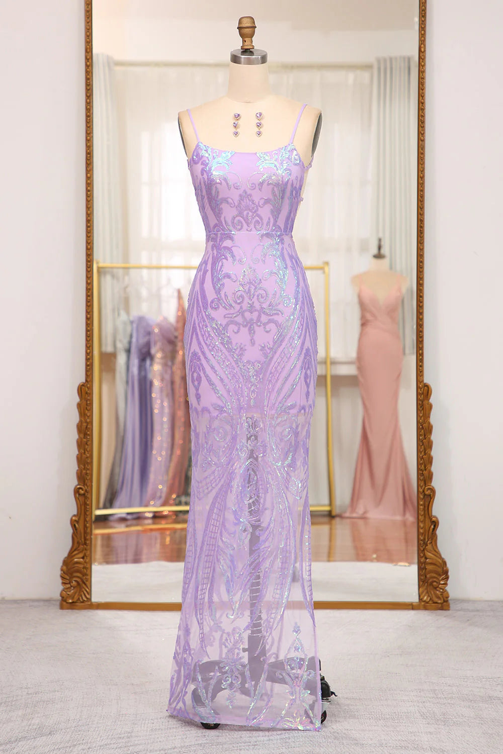 Model wearing an elegant long mermaid prom dress with spaghetti straps.