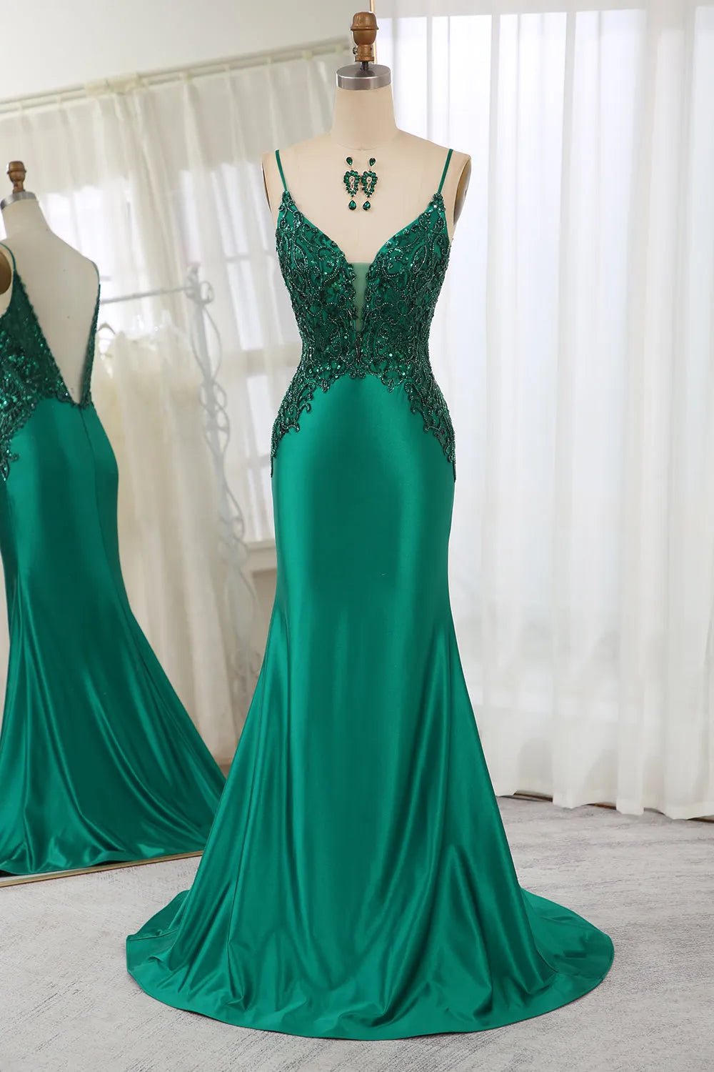 Dark green mermaid prom dress with appliques and spaghetti straps.