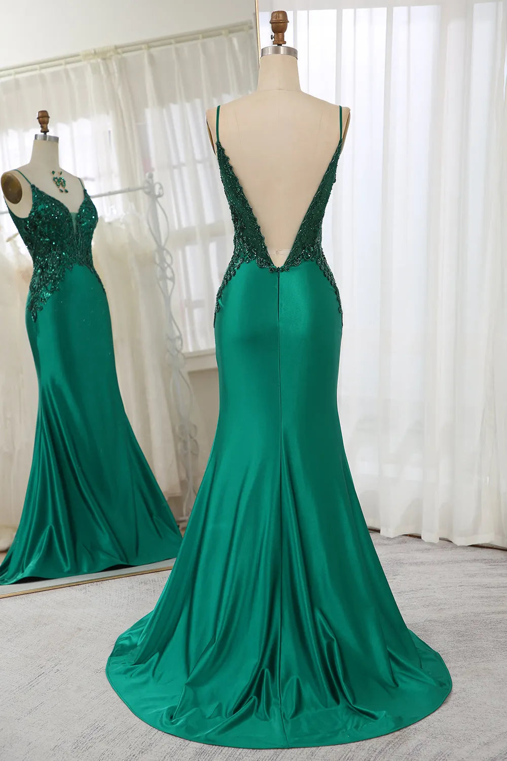 Side view of a dark green satin mermaid prom dress.