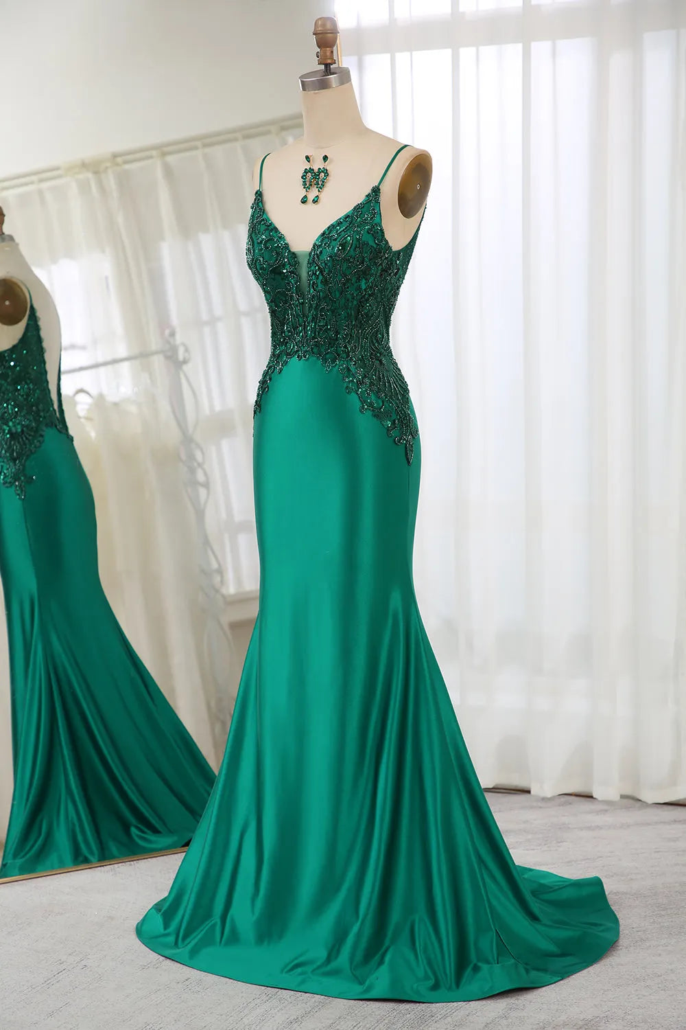 Back view of dark green mermaid prom dress with a flowing train.