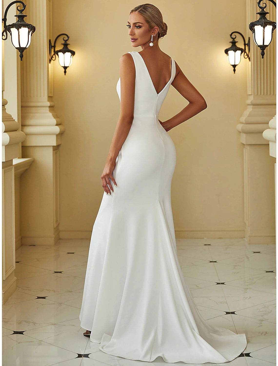 Close-up of the scoop neckline and beaded details on a wedding dress.