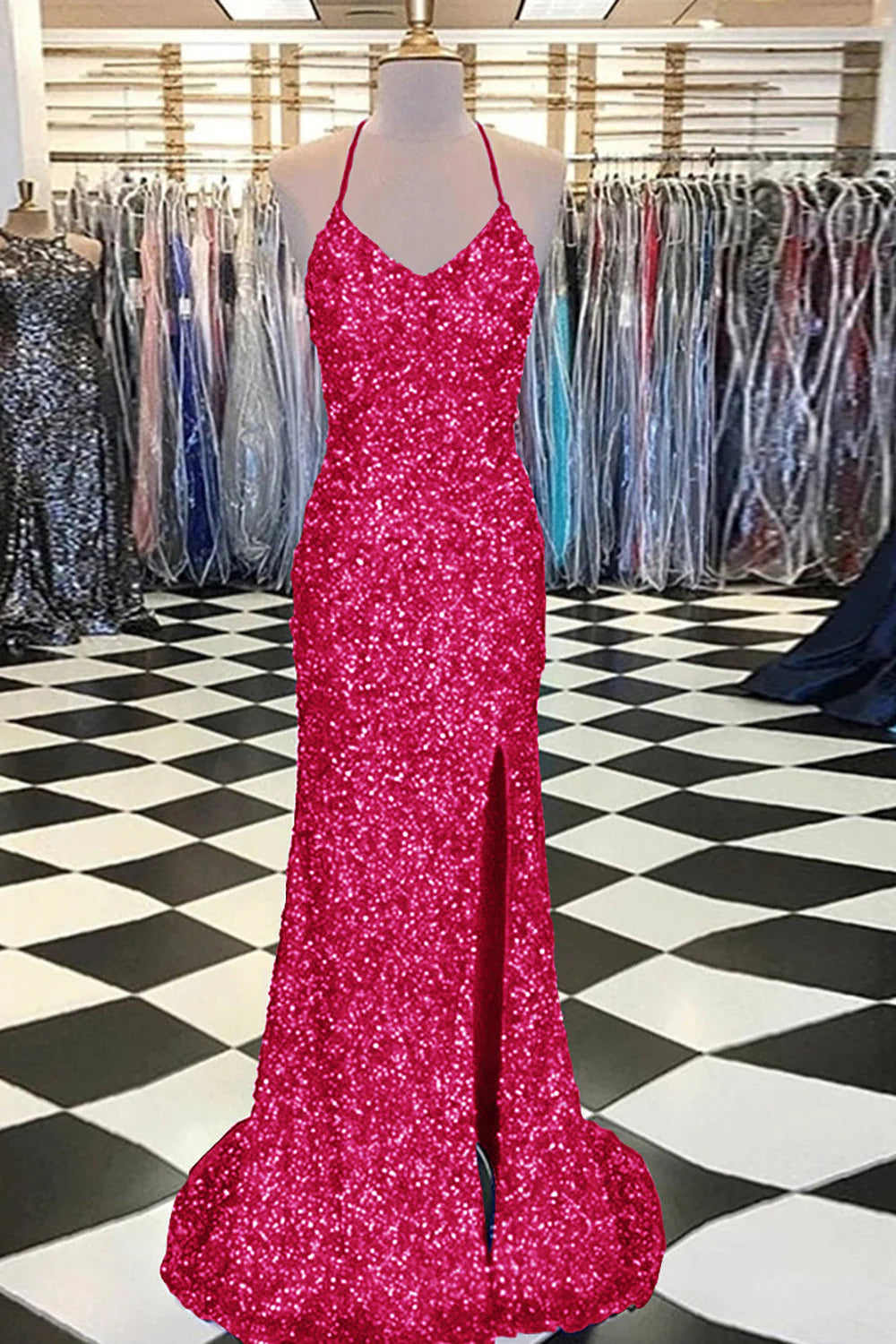 Woman in a dark blue mermaid sequin prom dress, posing elegantly.