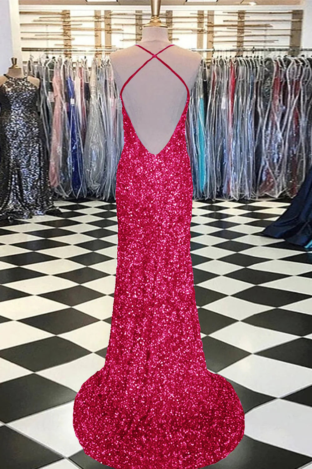 Woman in a fuchsia mermaid sequin prom dress, showcasing the back detail.
