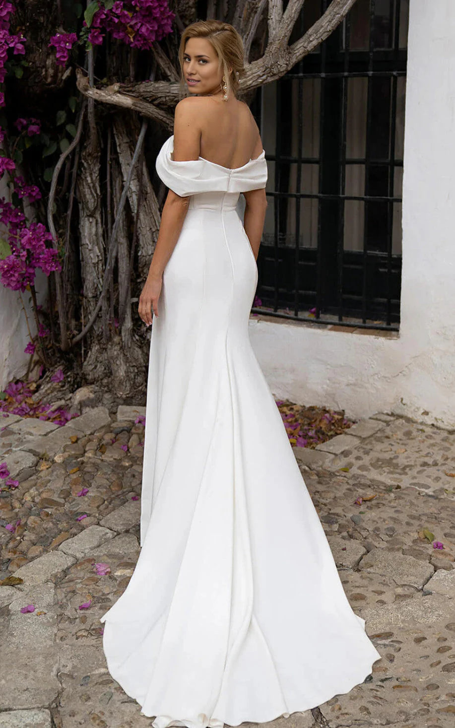 Back view of a model in a white mermaid satin wedding dress, showcasing the zipper closure.
