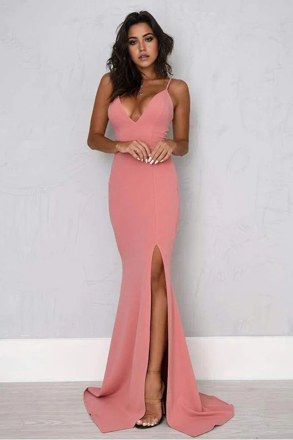 Woman wearing an elegant mermaid sheath prom dress with spaghetti straps and a high split.