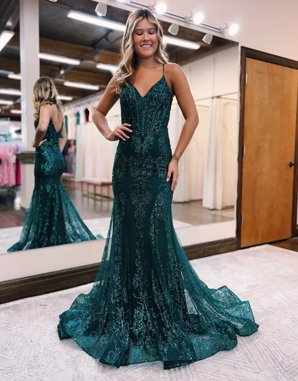 Elegant peacock blue mermaid prom dress with spaghetti straps and intricate appliques.