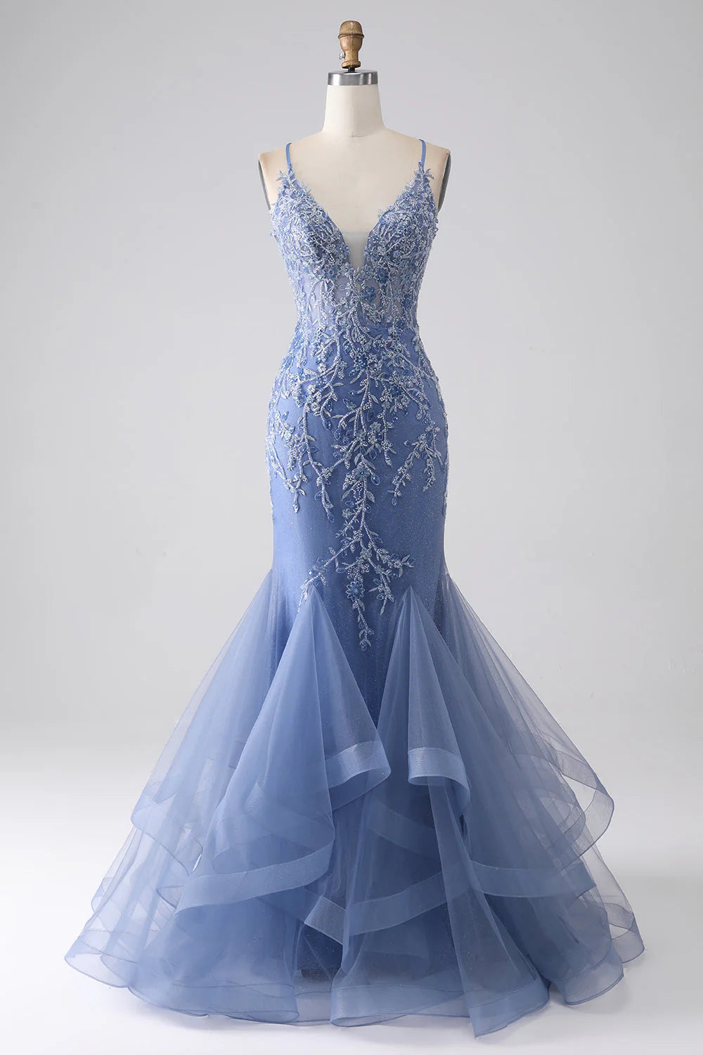 Front view of an elegant grey-blue mermaid prom dress with spaghetti straps and intricate beading.