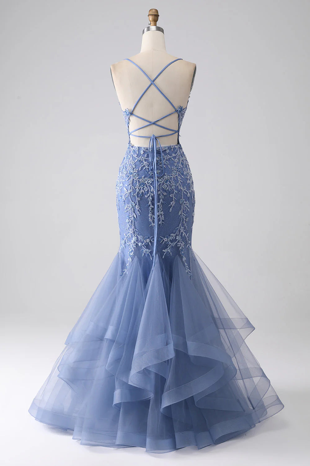 Side profile of the grey-blue mermaid gown, highlighting its fitted silhouette and appliques.