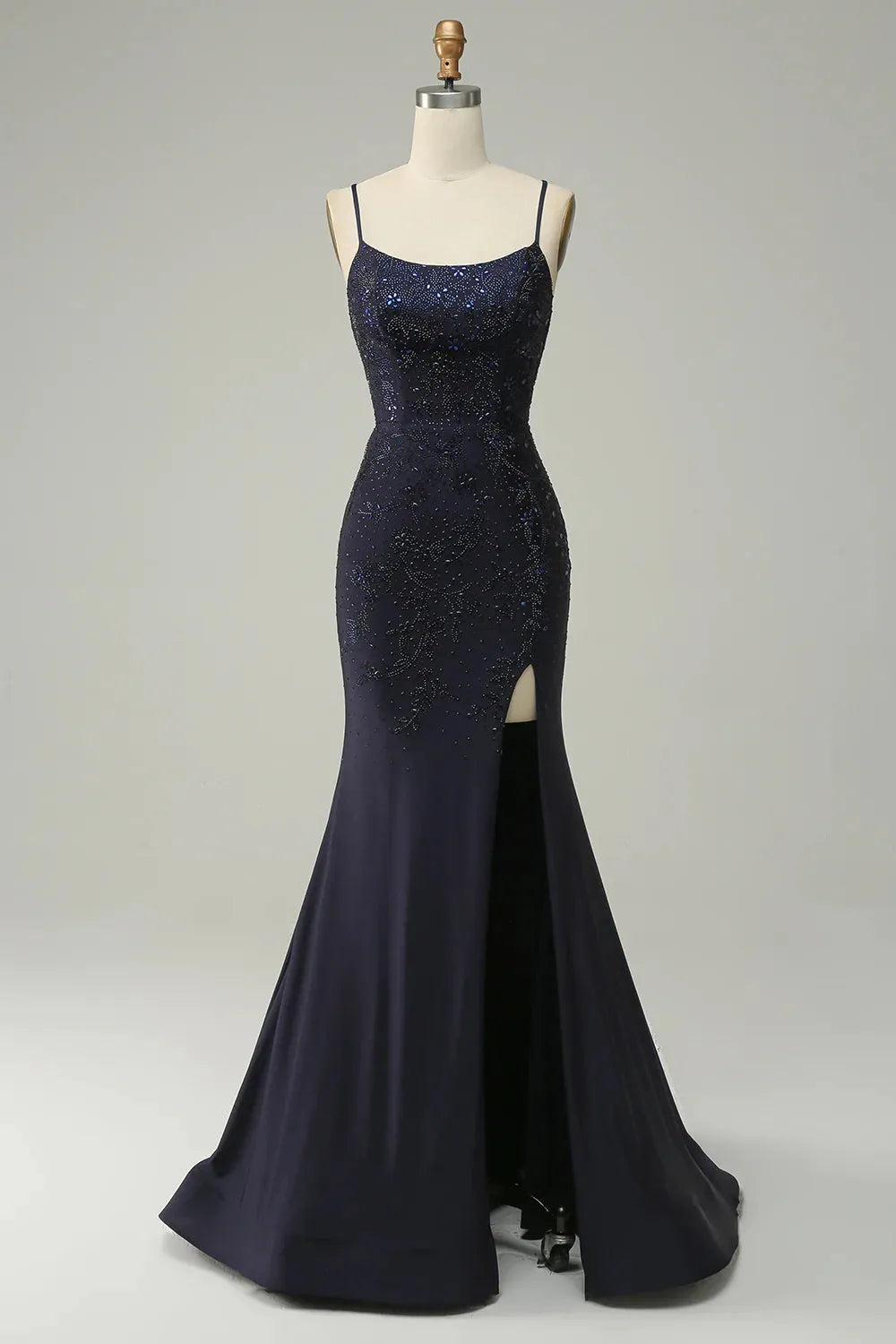 Navy mermaid prom dress with spaghetti straps and beaded bodice.
