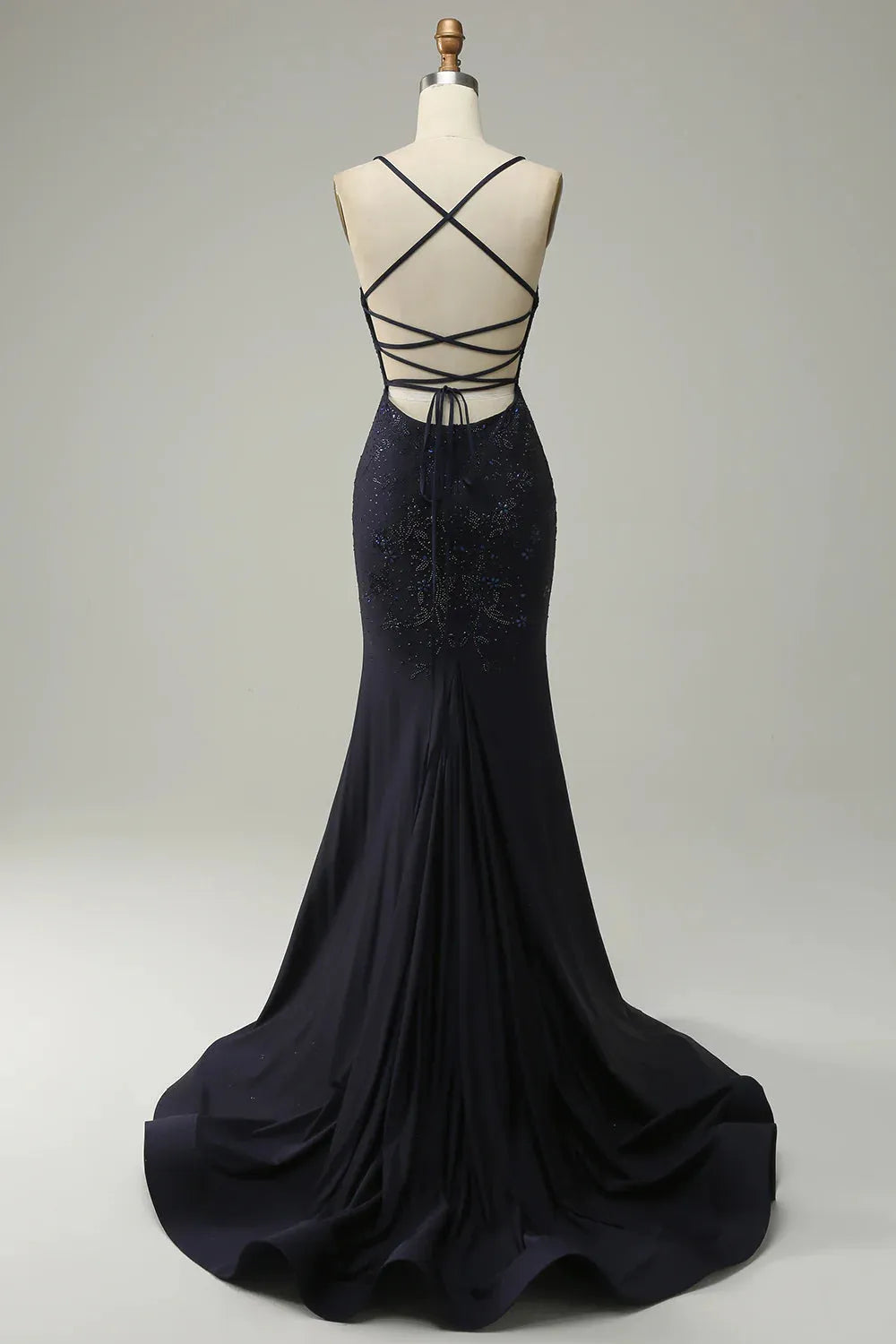 Side view of navy mermaid gown showing leg split and beading.