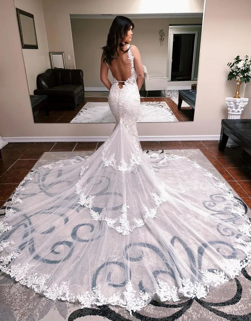 Mermaid wedding gown showcasing an open back design and delicate spaghetti straps.