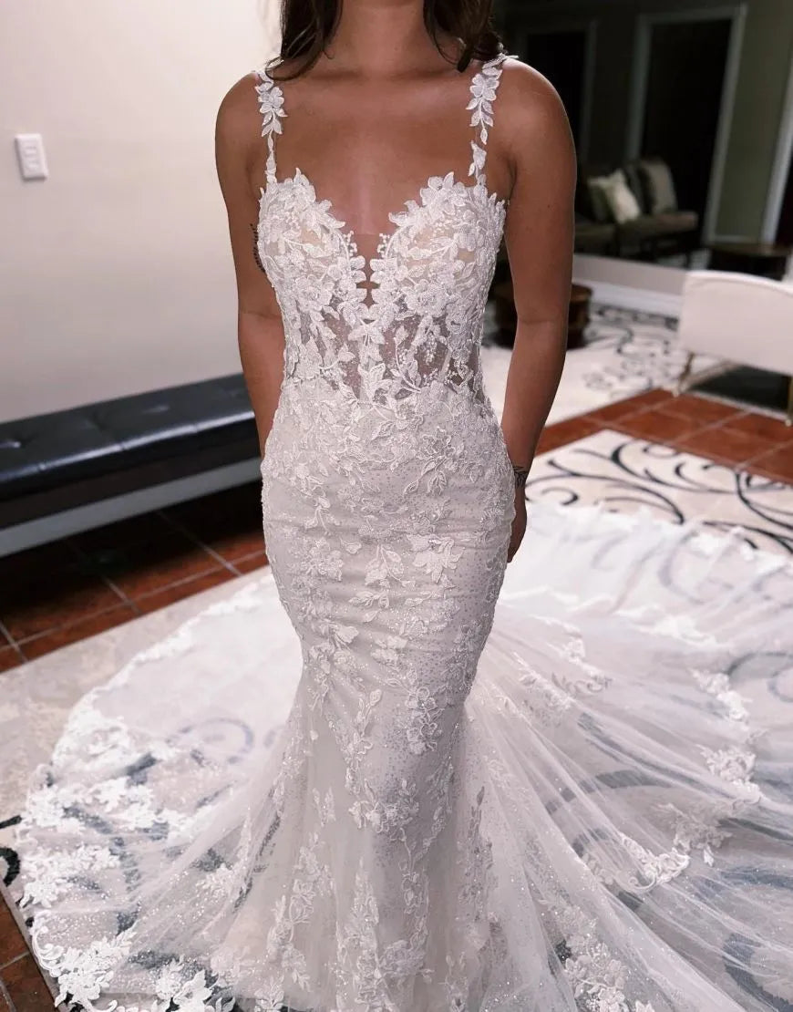 Side view of a mermaid wedding dress with a flowing train and fitted silhouette.