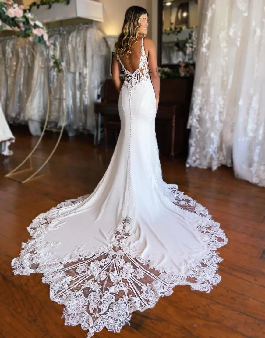 Elegant mermaid wedding gown with spaghetti straps and intricate appliques.