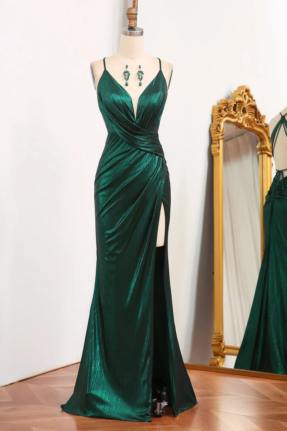 Woman wearing a dark green mermaid prom dress with spaghetti straps and keyhole neckline.