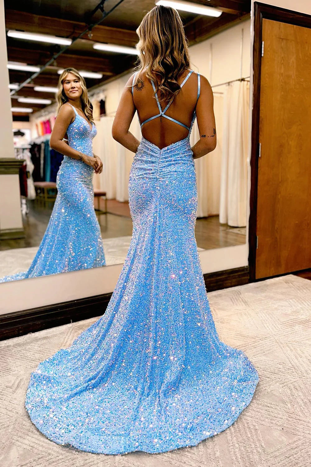 Back view of a long sequined mermaid dress, highlighting the open back.