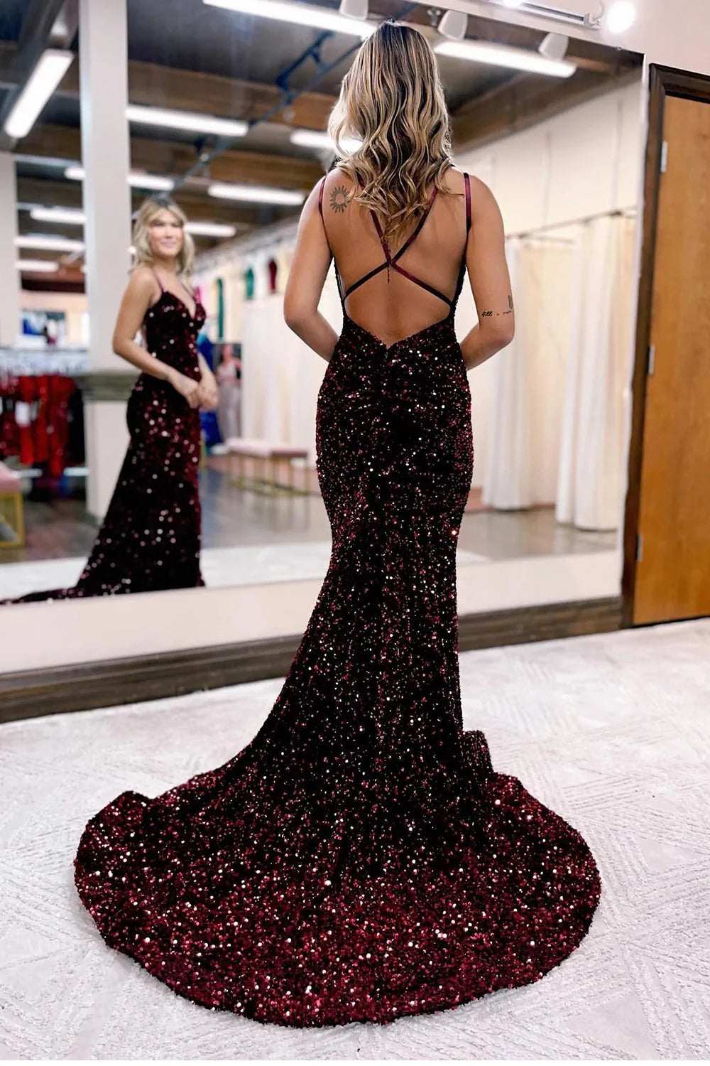 Mermaid style evening gown with a flowing train and sequin embellishments.