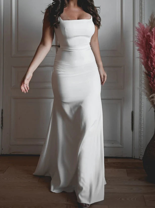Elegant bride wearing a white mermaid wedding dress with a square neckline, standing gracefully.