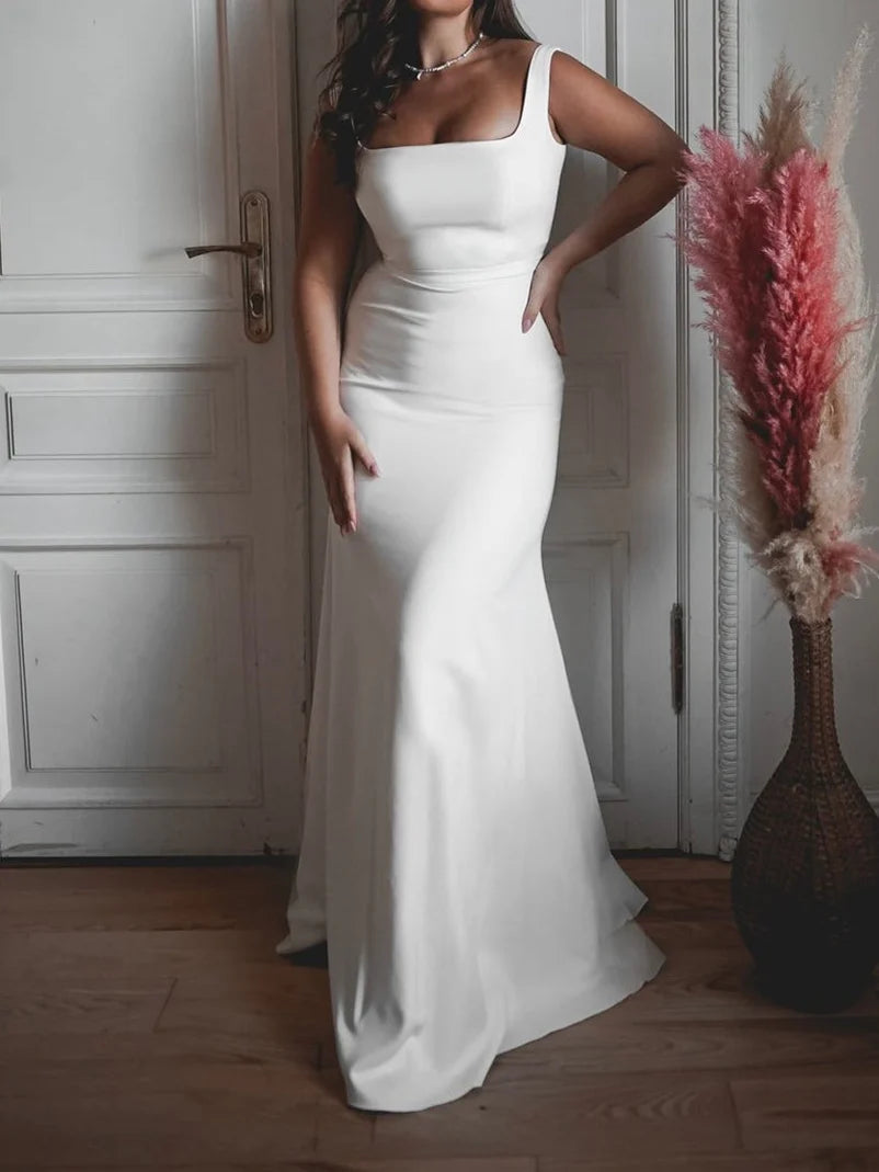 Rear view of a bride in a white mermaid wedding dress, showcasing the floor-length train and elegant silhouette.