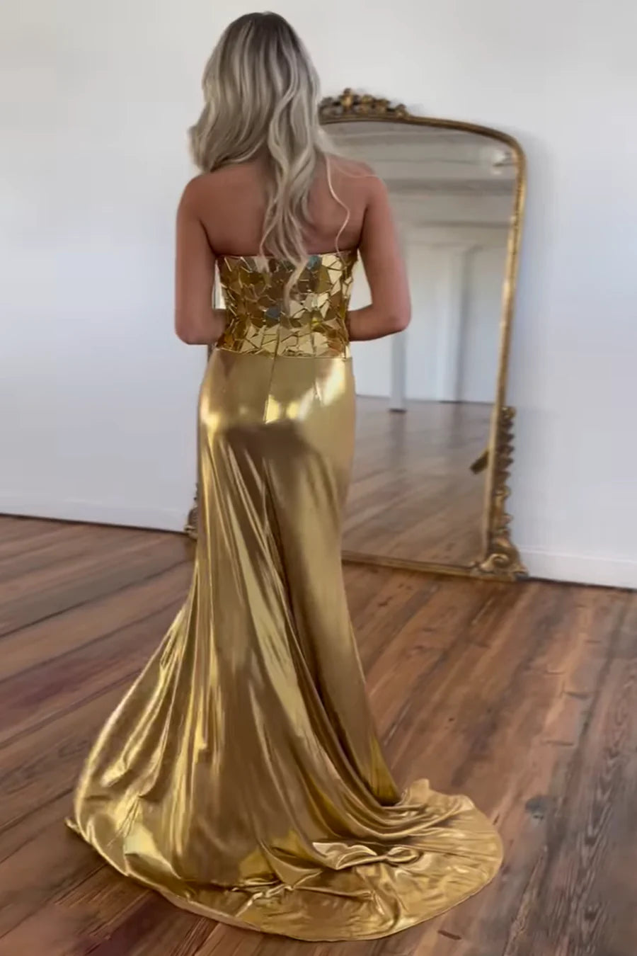 Back view of the gold mermaid strapless evening gown.