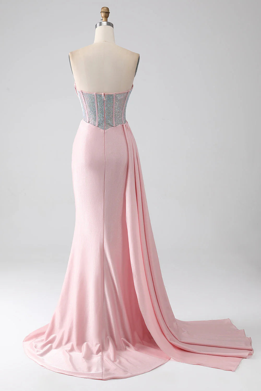 Back view of a pink mermaid strapless gown with a flowing skirt.