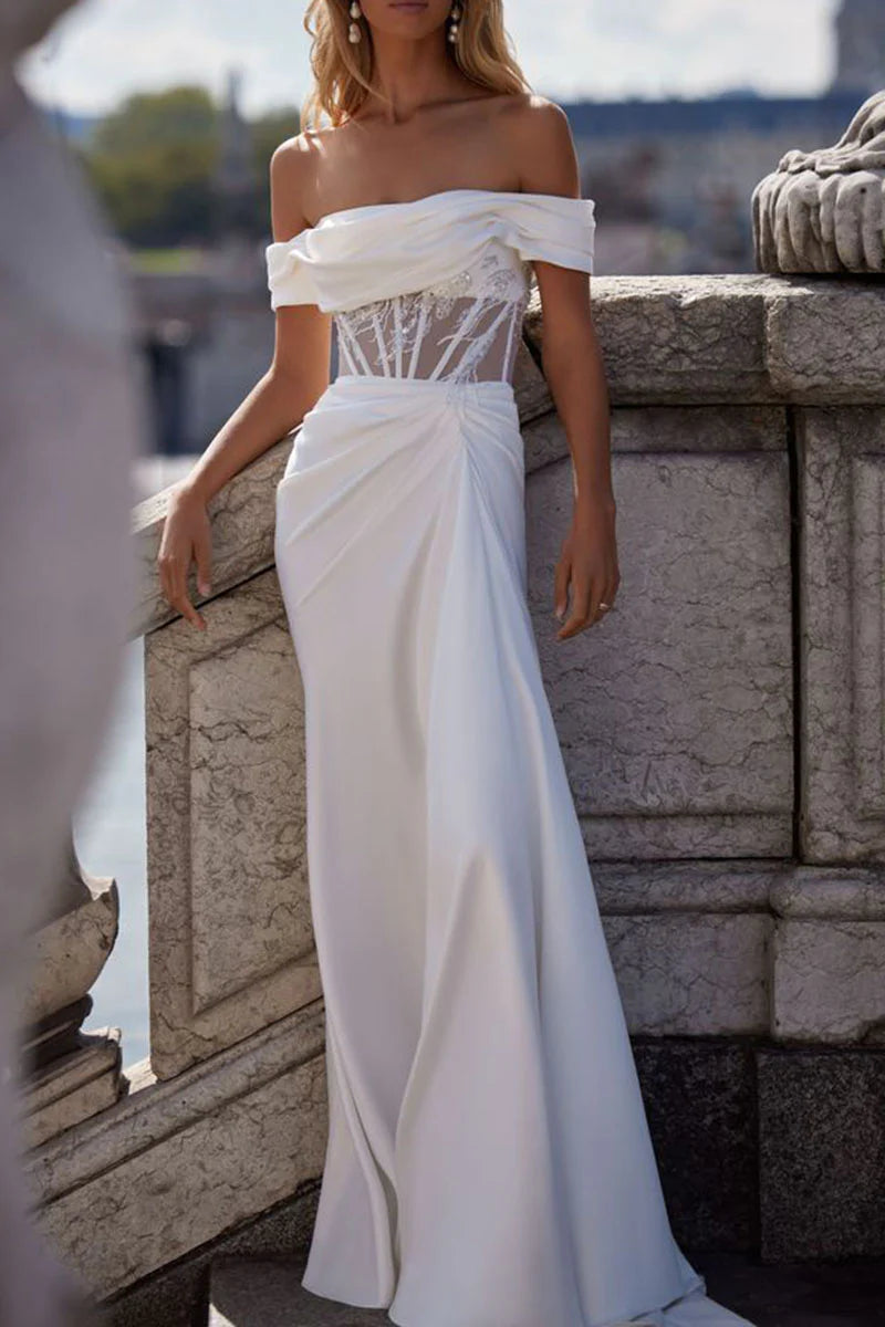 Full view of a woman wearing an elegant strapless mermaid satin wedding dress.