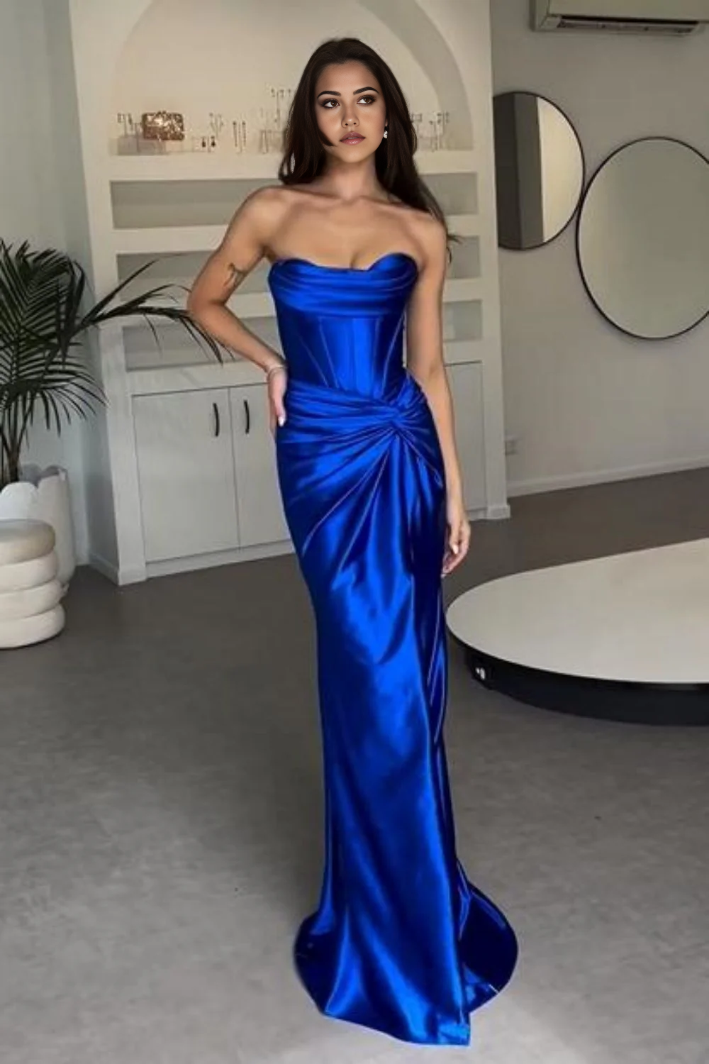 Model wearing an elegant mermaid strapless satin long prom dress with a high split.