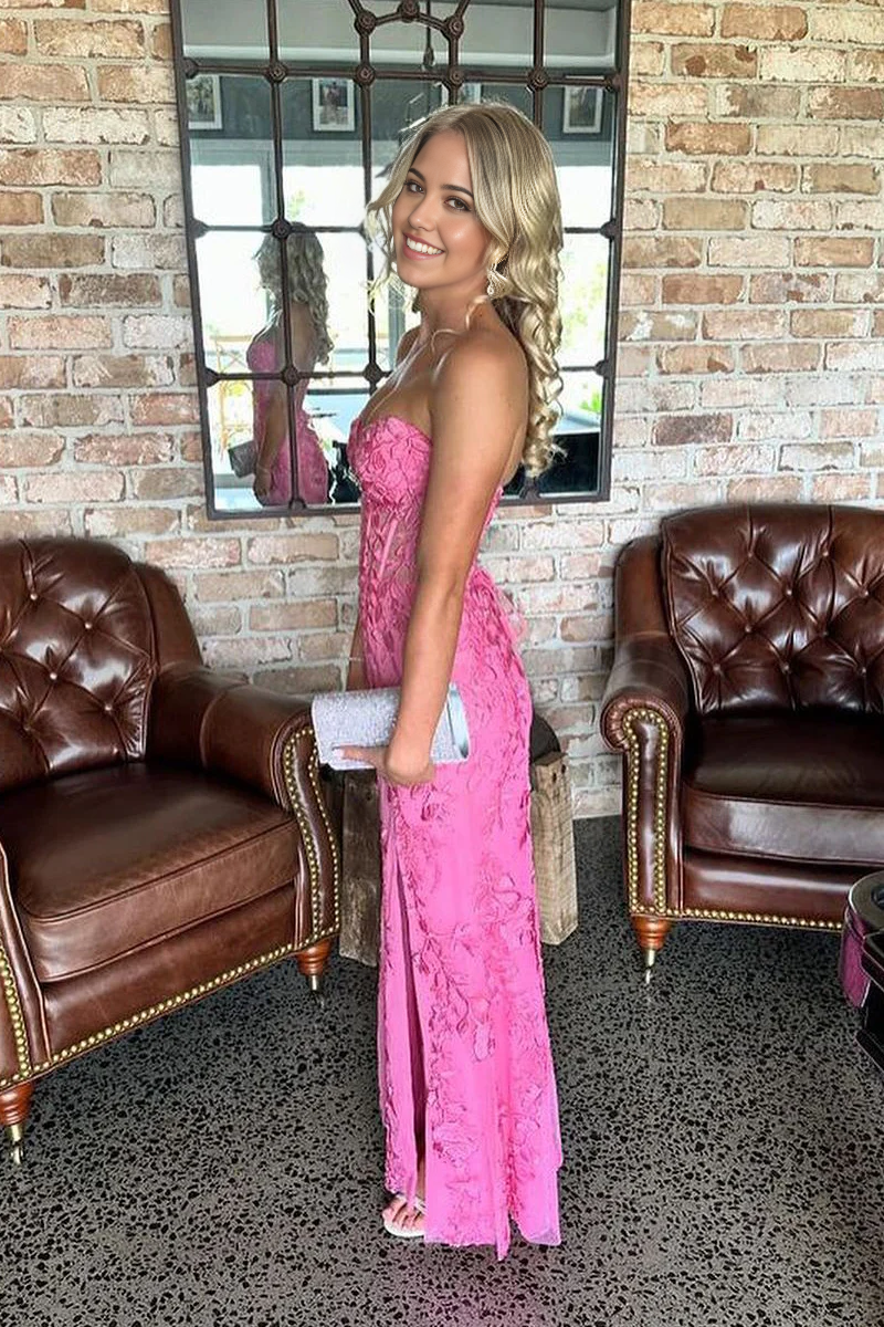 Back view of a pink mermaid prom dress showing lace appliques and flowing skirt.