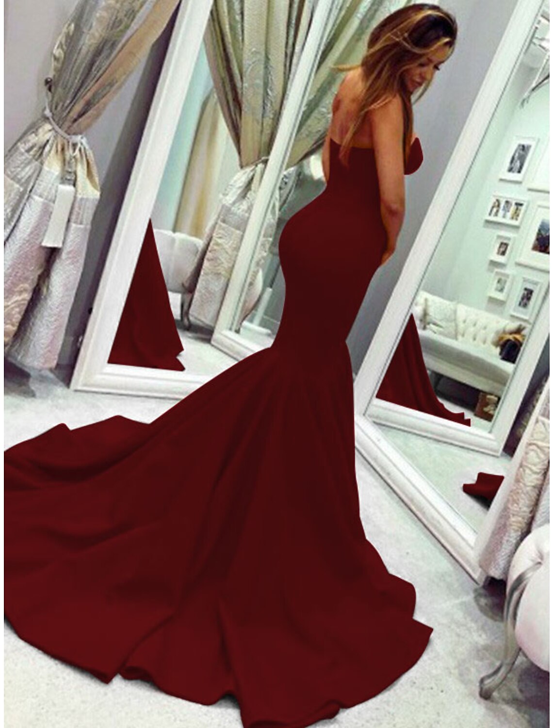 Back view of a woman in a strapless mermaid gown, highlighting the court train and fitted silhouette.