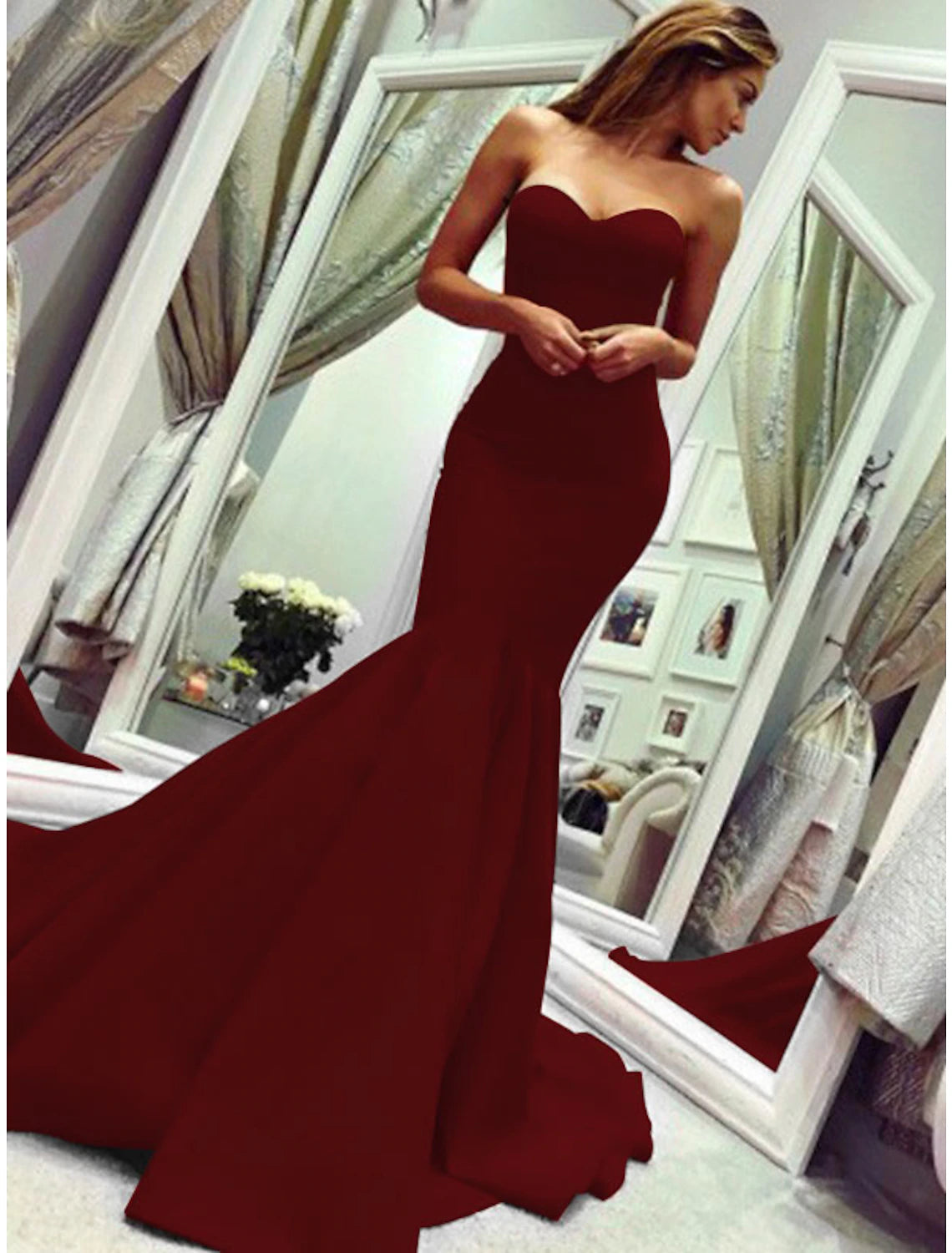 Woman in a strapless mermaid dress, looking over her shoulder, showing the elegant back.