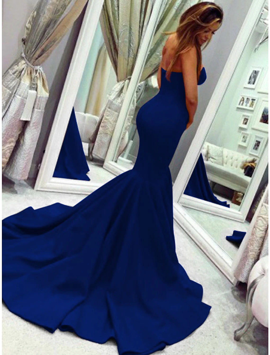 Woman walking in a strapless mermaid evening dress, emphasizing the flow of the court train.