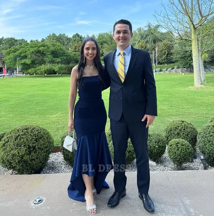 Woman wearing a navy blue strapless mermaid formal dress with ruffles.