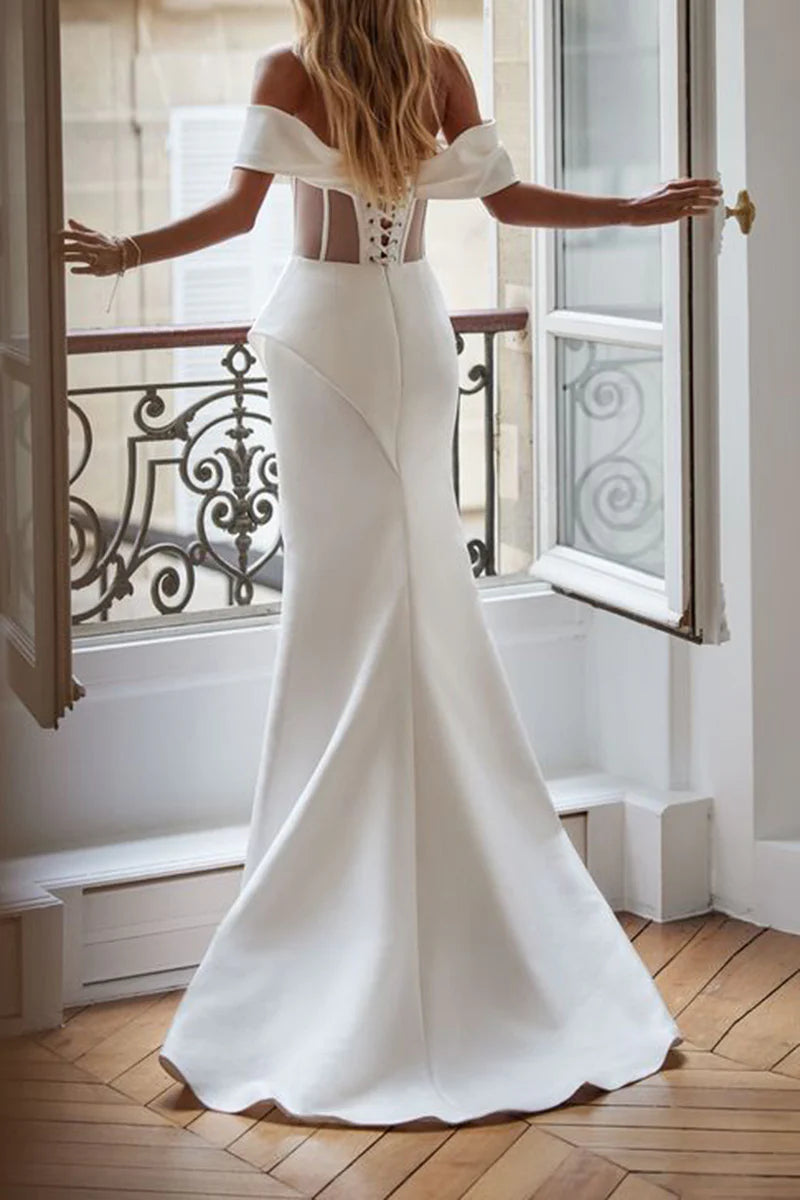 Bride wearing a strapless mermaid satin wedding dress, holding a white bouquet.