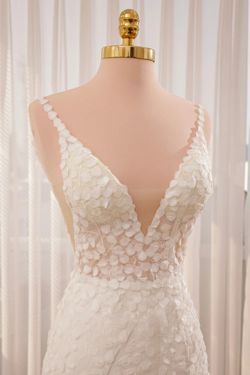 Close-up of intricate lace and applique details on a bridal gown.
