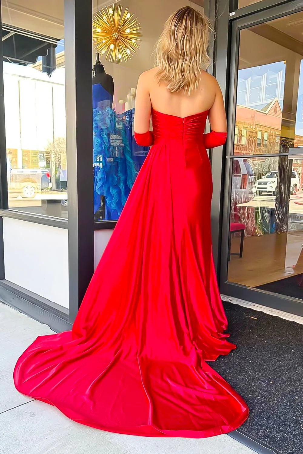 Side profile of a black mermaid prom dress, highlighting the flowing skirt and leg split.