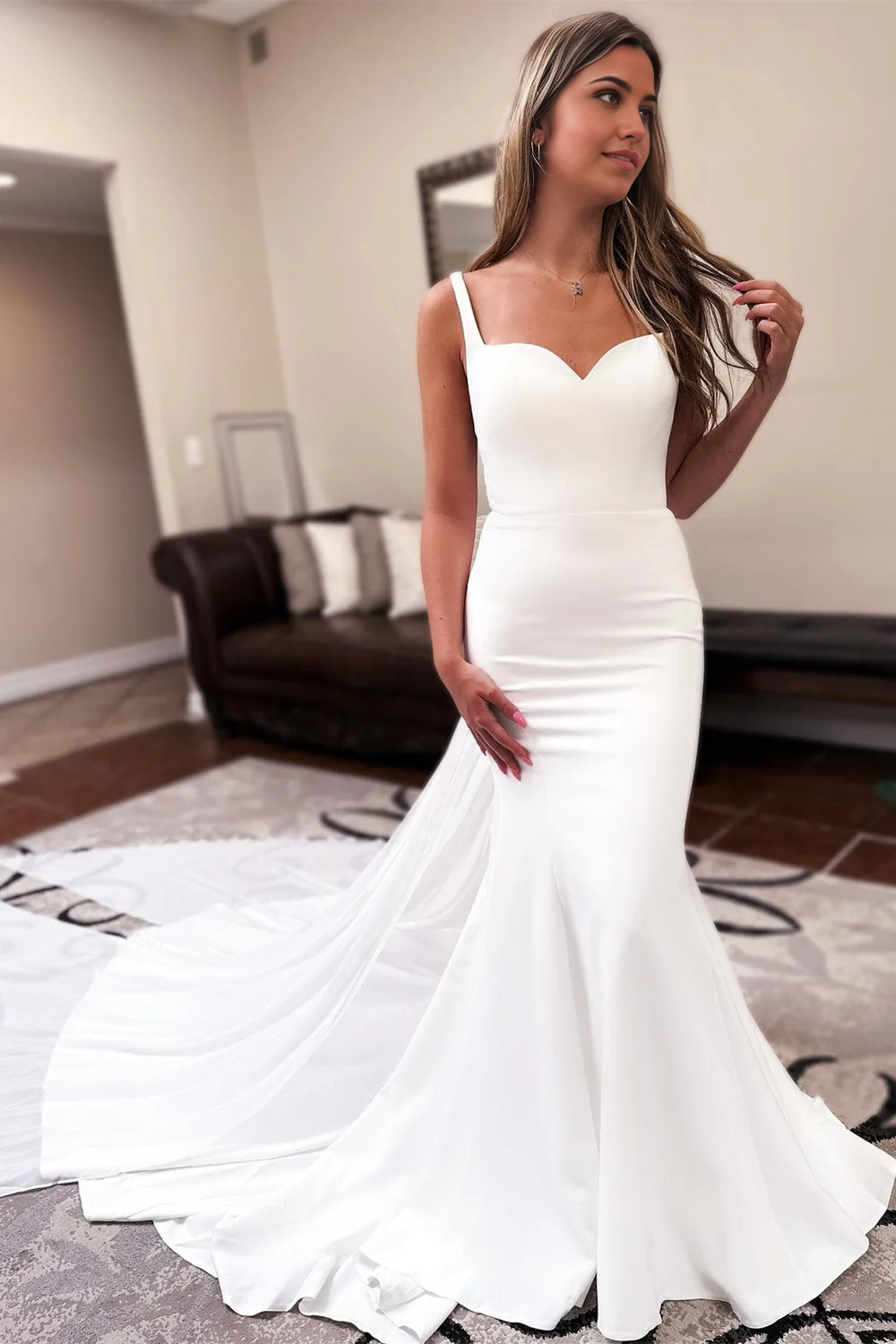 Elegant mermaid wedding dress with sweetheart neckline and attached train.