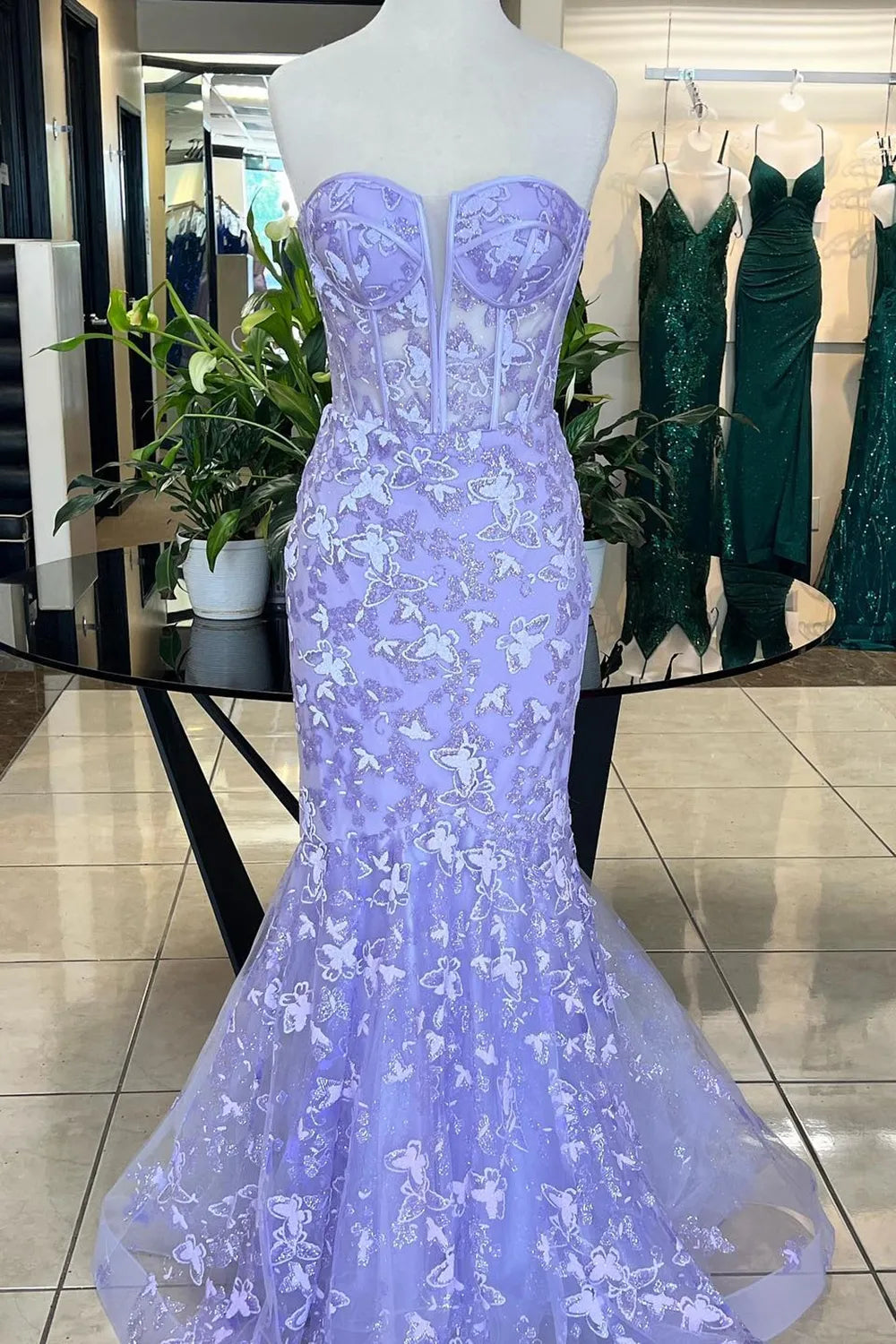 Woman wearing an elegant mermaid sweetheart corset prom dress with intricate embroidery.