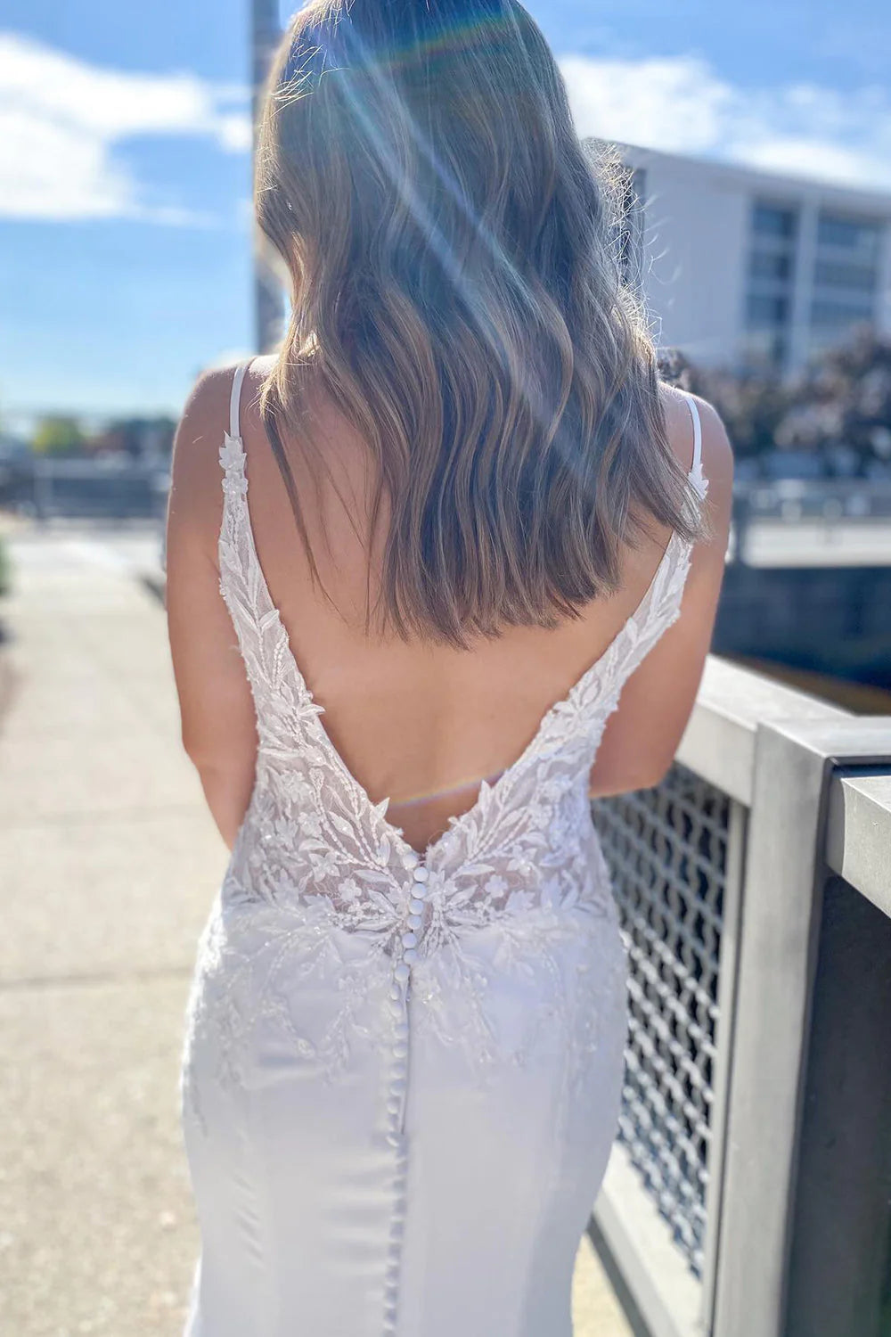 Back view of a mermaid sweetheart wedding dress featuring lace appliques and an open design.