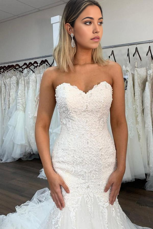 Side view of elegant mermaid bridal gown with ruffles.