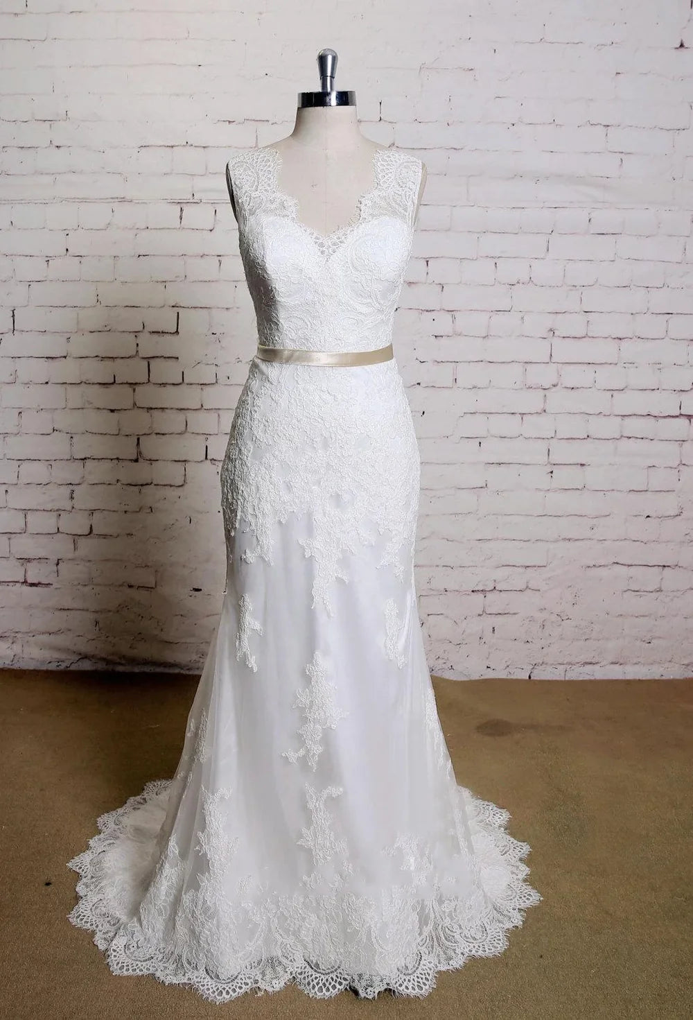 Elegant mermaid lace wedding dress with a sweetheart neckline and satin sash.
