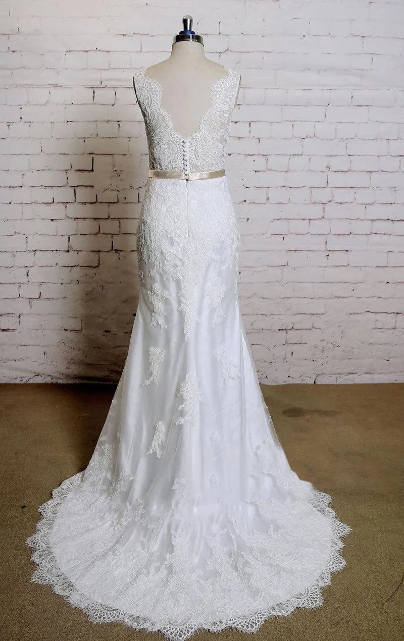 Back view of a mermaid wedding dress showcasing intricate lace details and a flowing train.