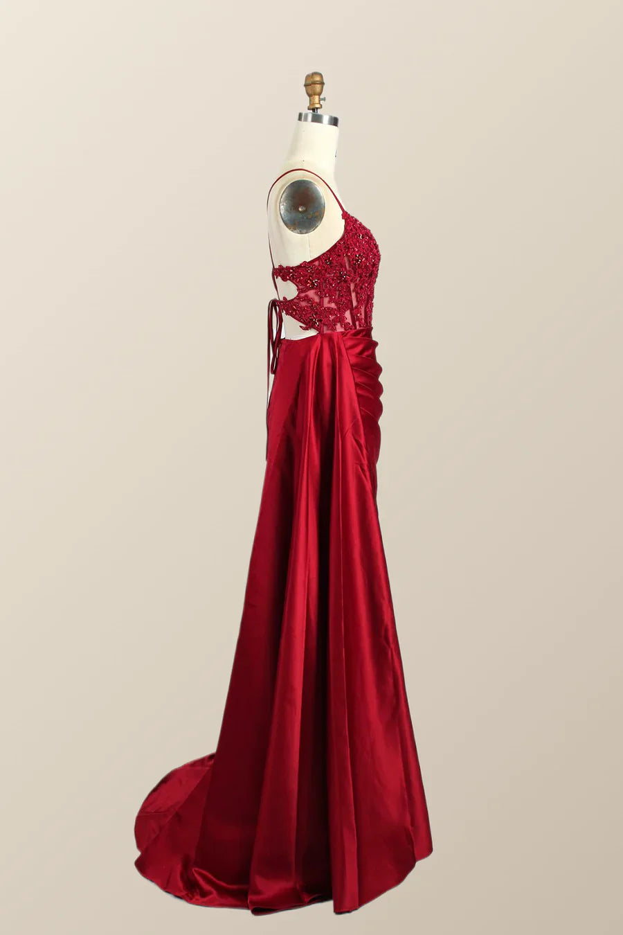 Full length view of a red mermaid formal gown with a side slit.