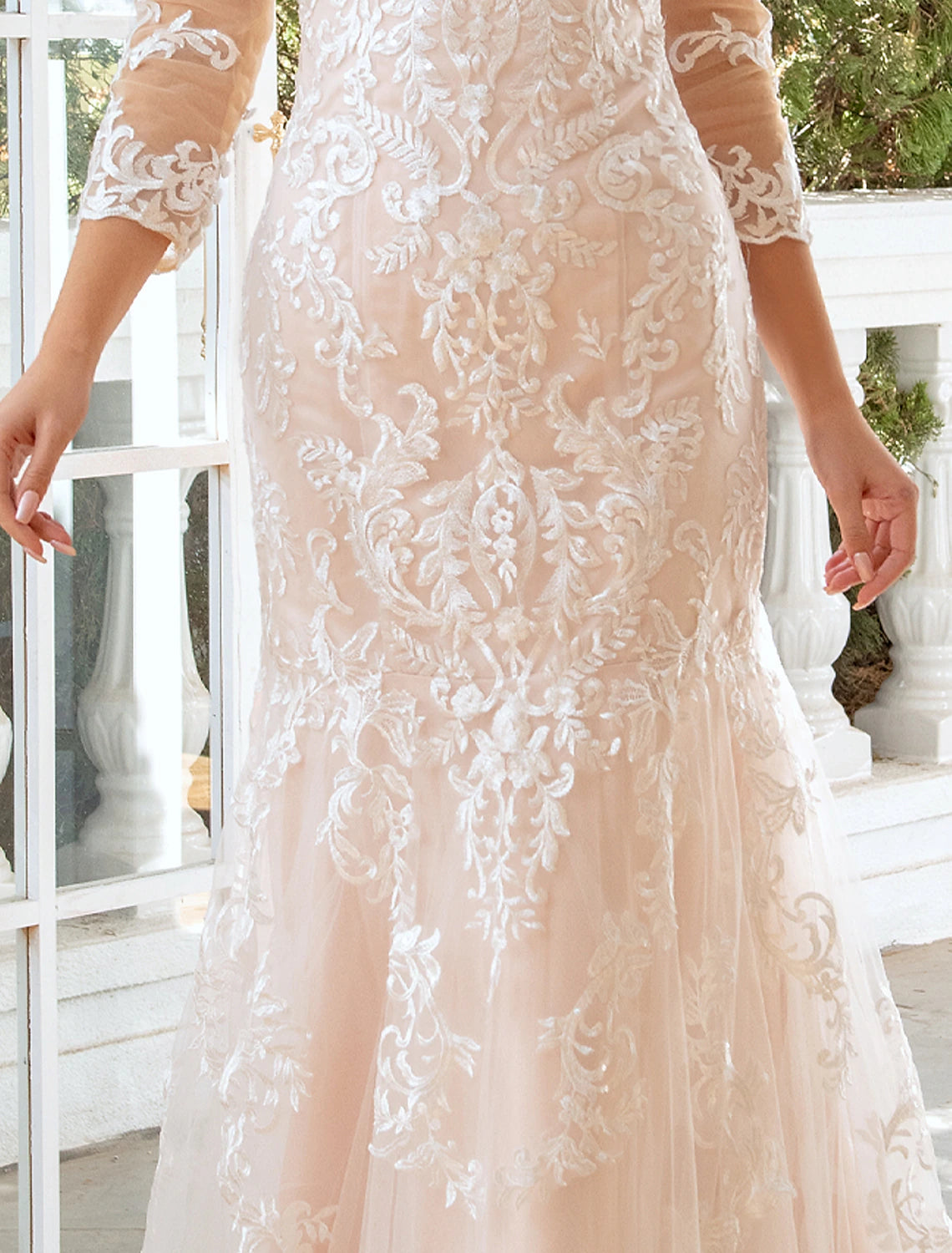 Bride posing in a formal mermaid wedding dress with elegant train.